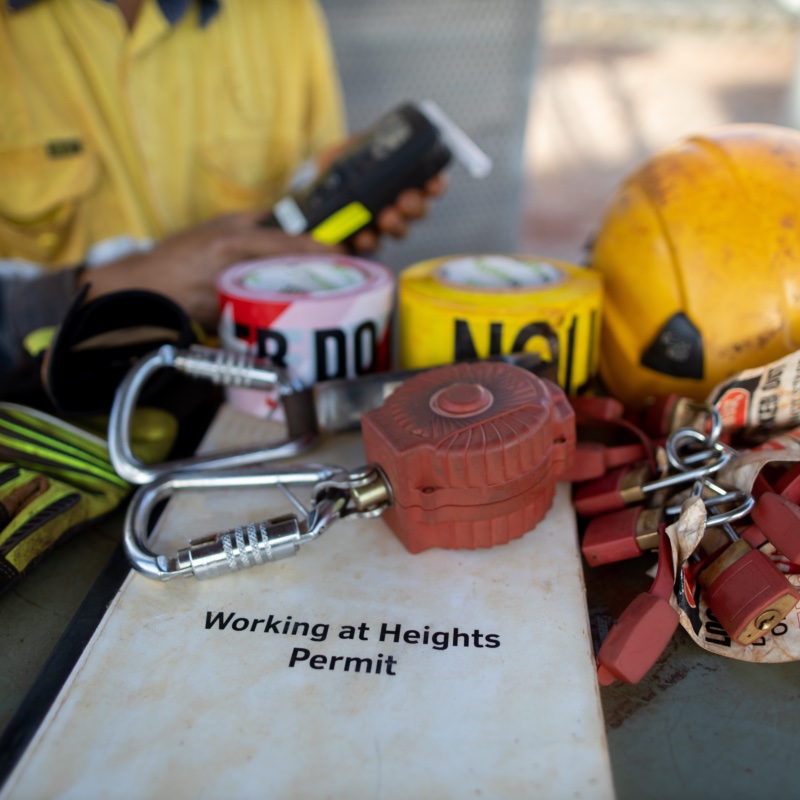 PTW Knowledge Hub: working at heights permit, fall arrest carabiner, lockout-tagout devices and barrier tape laid out on site